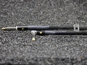 Custom-made Bangee audio patch cable 6.35 mm jack, black braided, angled and straight connectors with copper tips, grey background