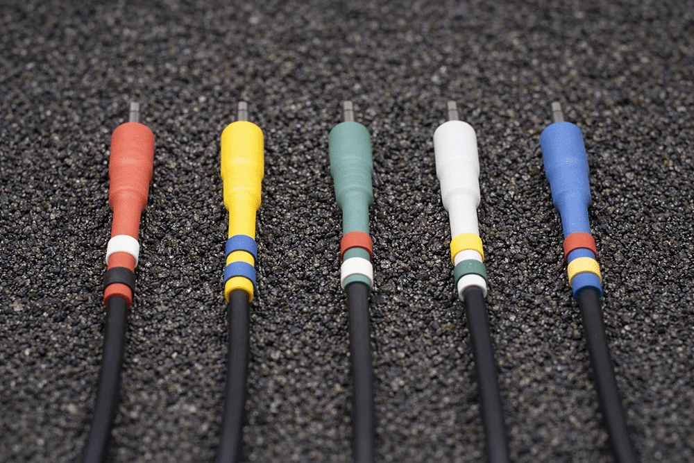 Black Europatch Bangee patch cables with coloured sheaths for Eurorack synthesizers, grey background.