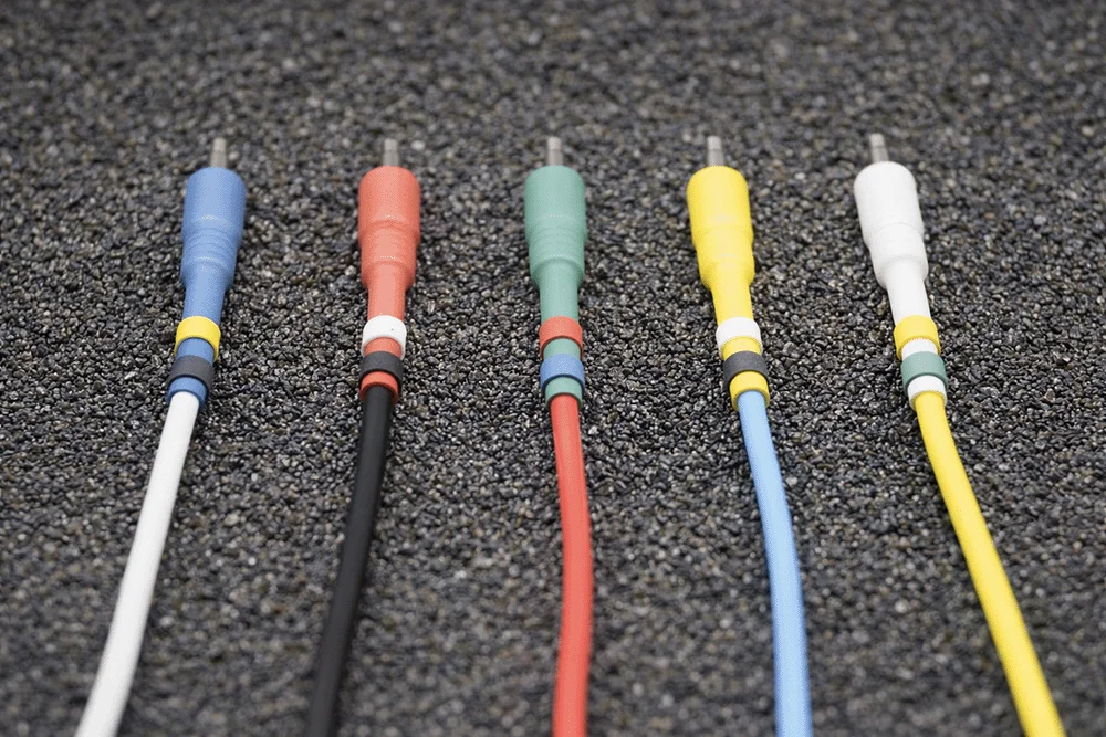 Europatch Bangee patch cables with coloured sleeves for Eurorack synthesizers, grey background.