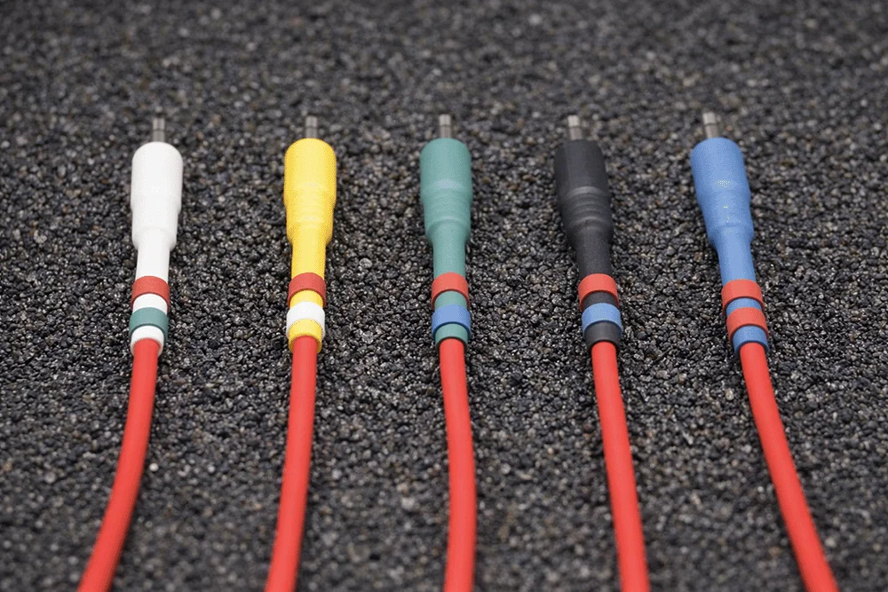 Red Europatch Bangee patch cables with coloured sheaths for Eurorack synthesizers, grey background.